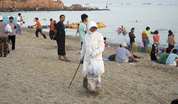 大連の海水浴場を清掃する職員。