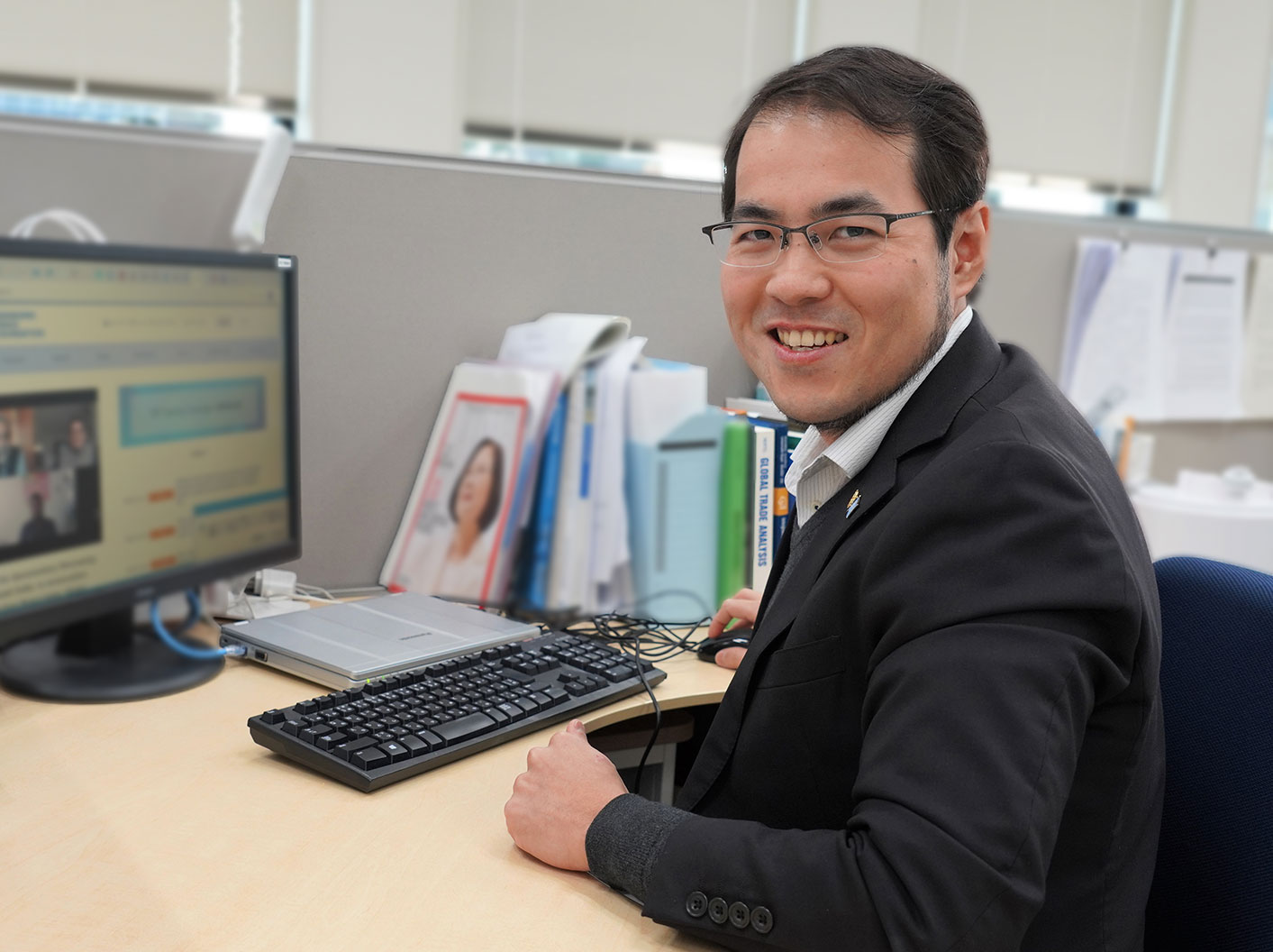 Mr. Huang sitting at his desk