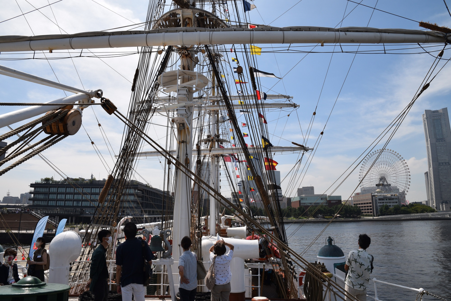 Visitors look up at the flags of countries around the world hoisted on the ropes.