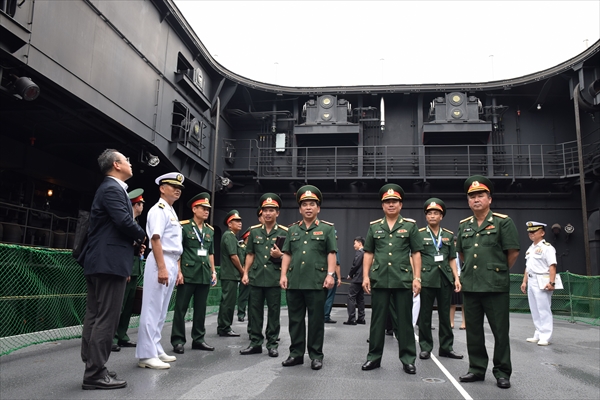 海上自衛隊舞鶴基地で、ヘリコプター搭載護衛艦「ひゅうが」に乗艦し航空機用昇降機に乗る訪日団一行