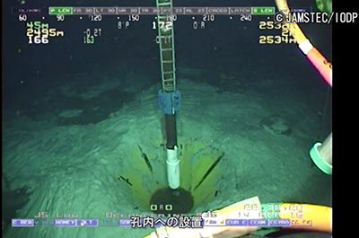 ■写真　水深約2,500mの掘削孔に地球深部探査船「ちきゅう」によって設置される孔内センサーシステム。